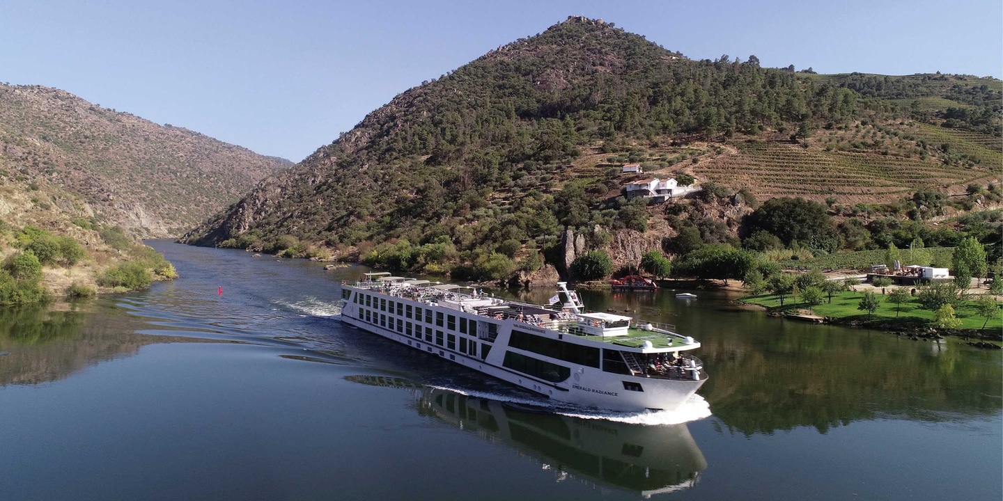 The Emerald-Radiance Star-Ship sails through Portugal’s Douro Valley, backed by green rolling hills.