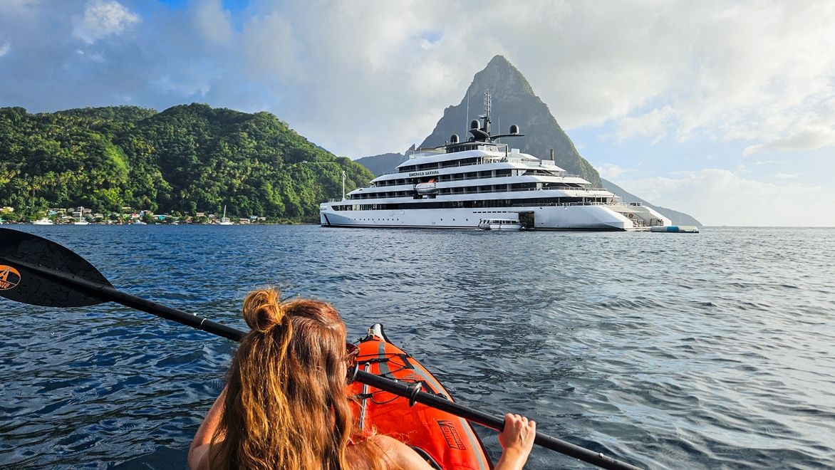 Luxury yacht sailing on a blue ocean with land seen in the distance