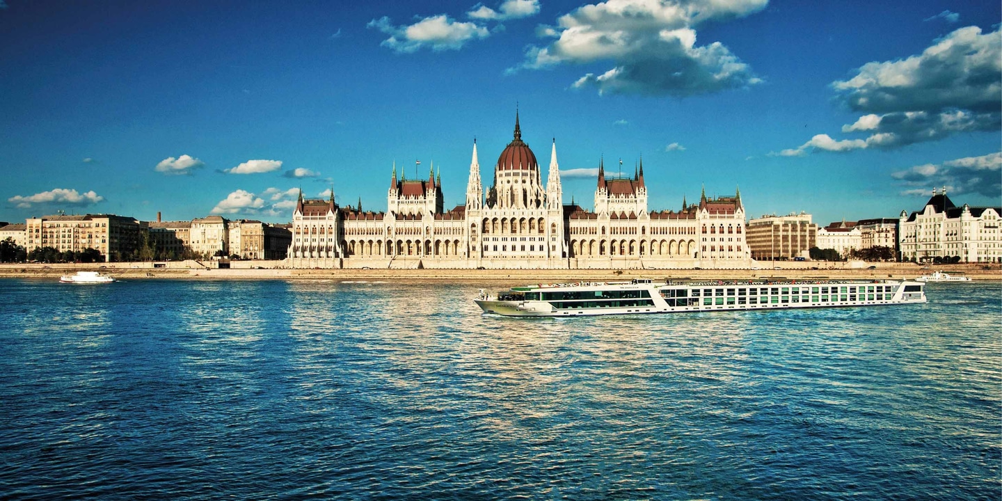 An Emerald Cruises luxury river ship sailing down the Danube in Budapest in front of the Parliament building