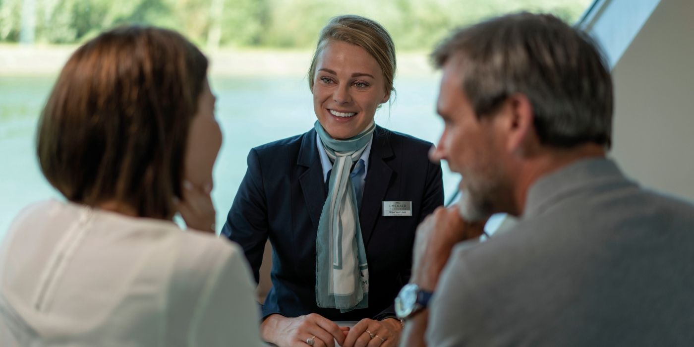 A Cruise Director helps two guests with their enquiry