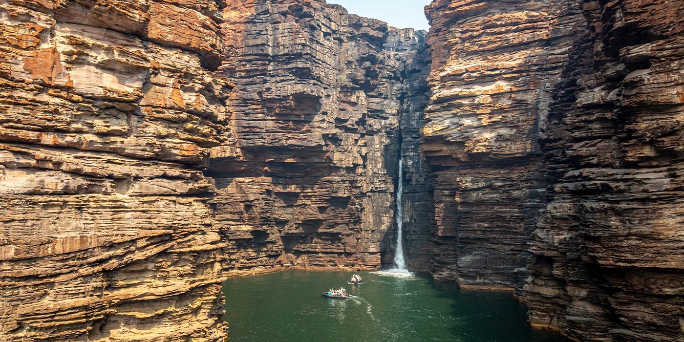 Zodiacs cruising beneath the towering cliffs of King George Falls