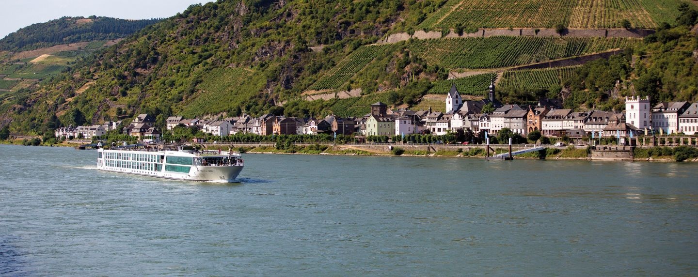 Emerald Dawn river cruise ship passing a hillside village and vineyards along the Rhine