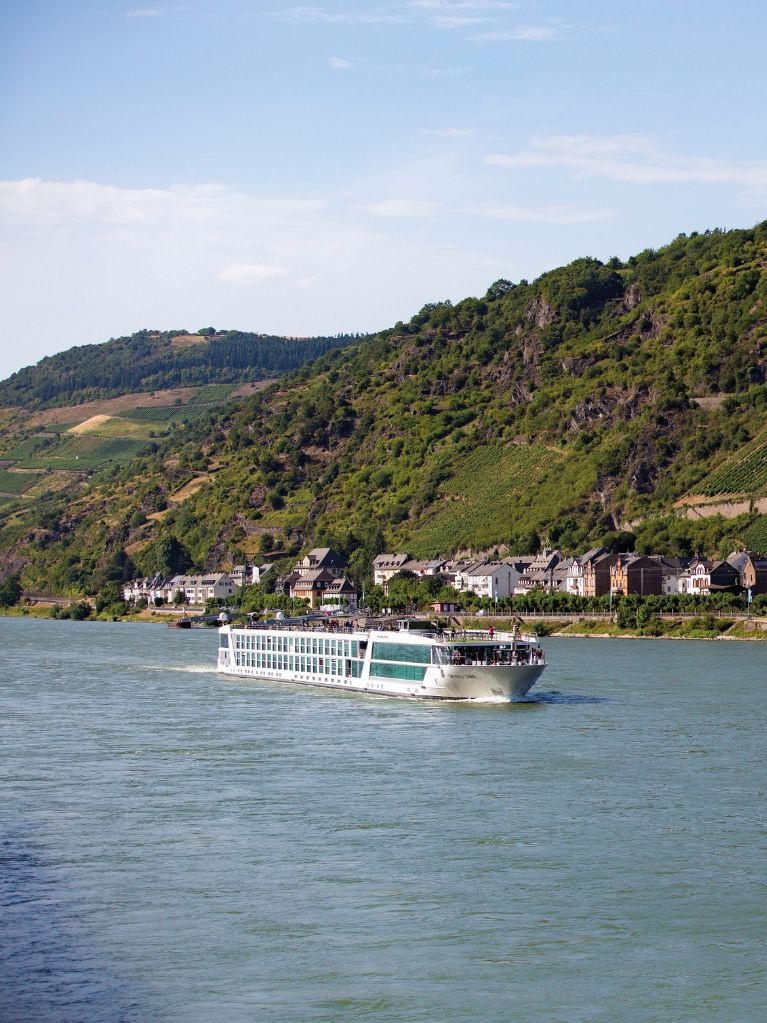 Emerald Dawn river cruise ship passing a hillside village and vineyards along the Rhine